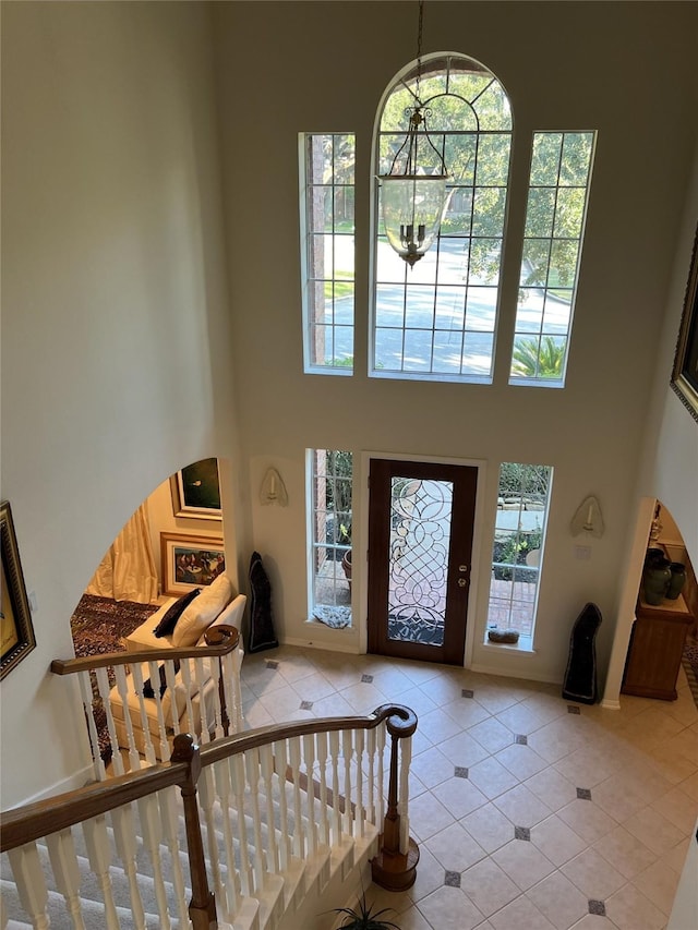 foyer entrance with a towering ceiling and light tile patterned floors