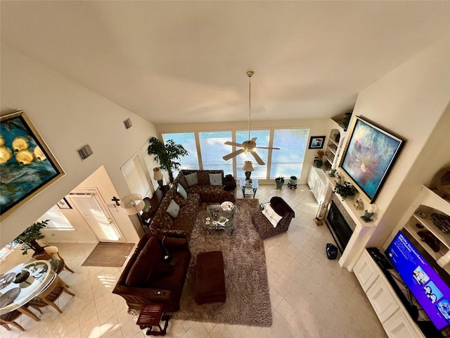 tiled living room with ceiling fan and lofted ceiling