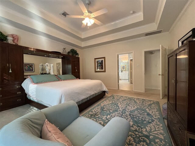 bedroom featuring a tray ceiling, ceiling fan, and crown molding