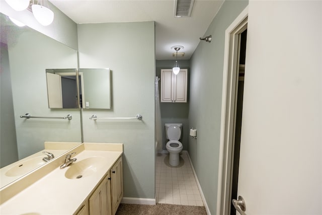 bathroom with vanity, tile patterned flooring, and toilet