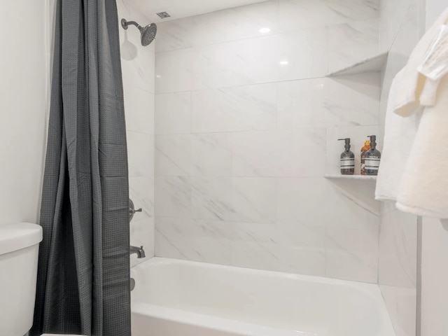 bathroom featuring shower / tub combo and toilet