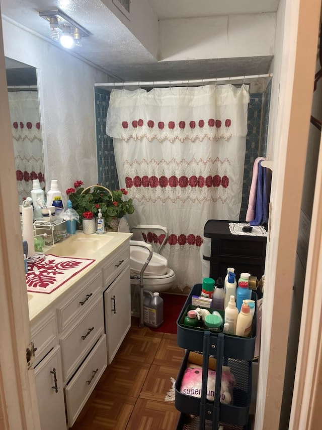 bathroom with a shower with curtain, vanity, parquet flooring, toilet, and a textured ceiling