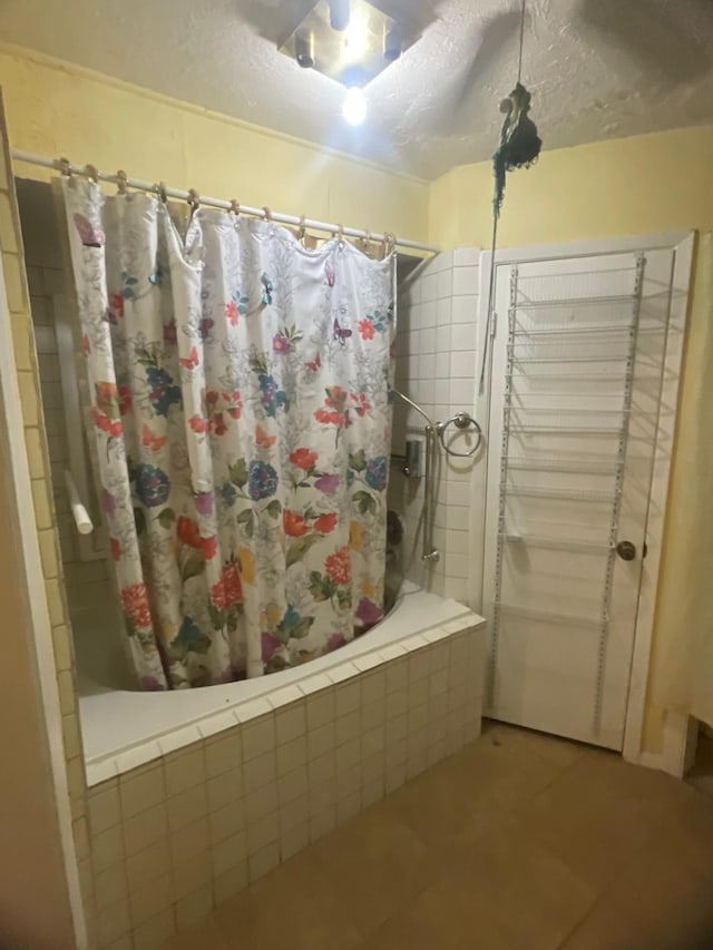 bathroom with shower / bath combination with curtain and tile patterned floors