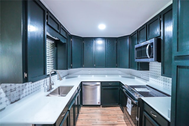 kitchen with appliances with stainless steel finishes, light wood-type flooring, sink, and tasteful backsplash