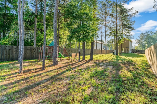 view of yard featuring a playground and a fenced backyard