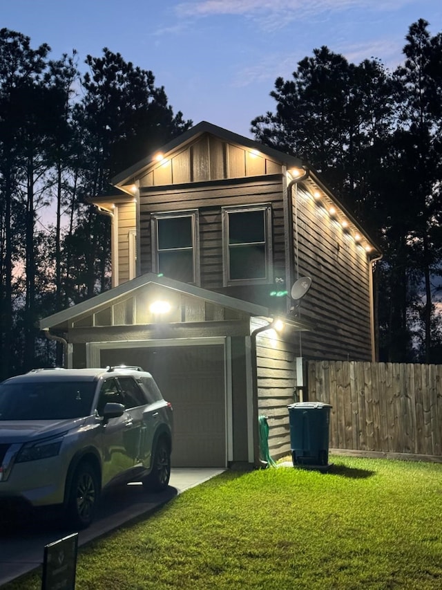 property exterior at dusk featuring concrete driveway, a lawn, and fence