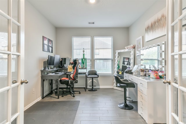 home office with wood-type flooring and french doors