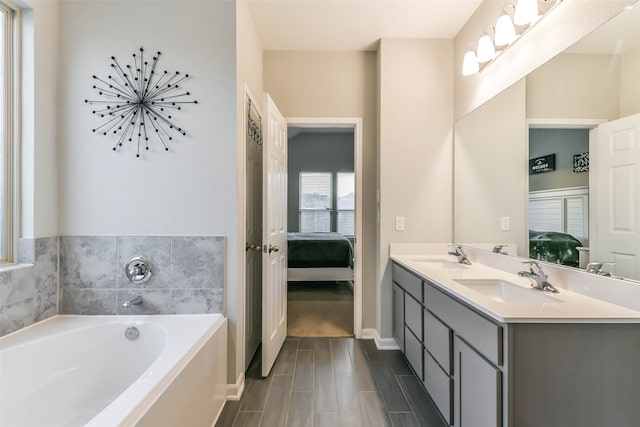 bathroom featuring a washtub, hardwood / wood-style floors, and vanity