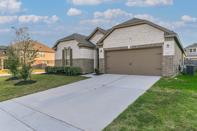 view of front of home featuring cooling unit, a front yard, and a garage