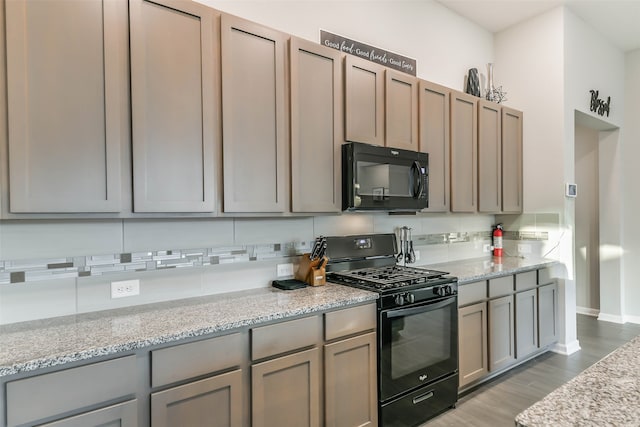 kitchen with black appliances, light hardwood / wood-style floors, and light stone counters