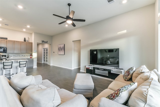 living room with ceiling fan and dark wood-type flooring