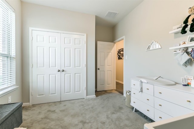 bedroom with light carpet and a closet