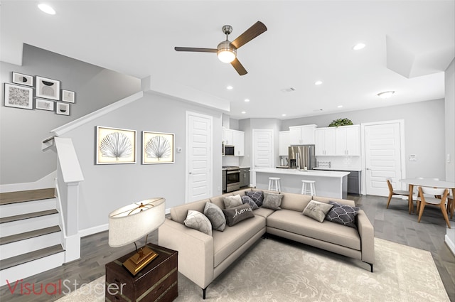 living room with dark wood-type flooring and ceiling fan