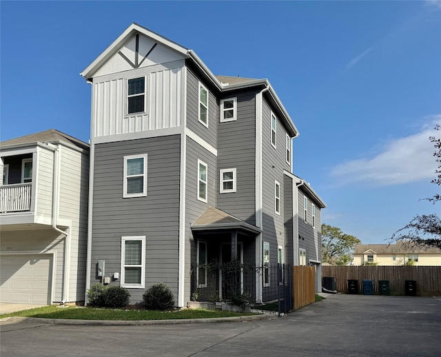 view of front of house with a garage and central air condition unit