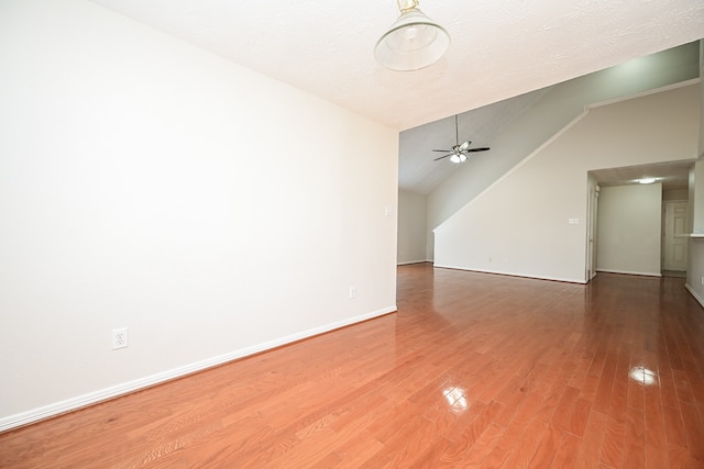 unfurnished room with ceiling fan, a textured ceiling, hardwood / wood-style floors, and vaulted ceiling