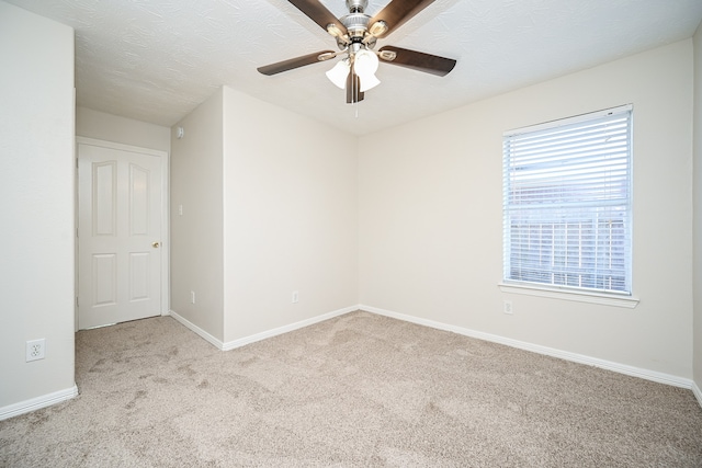 carpeted spare room featuring ceiling fan and a textured ceiling