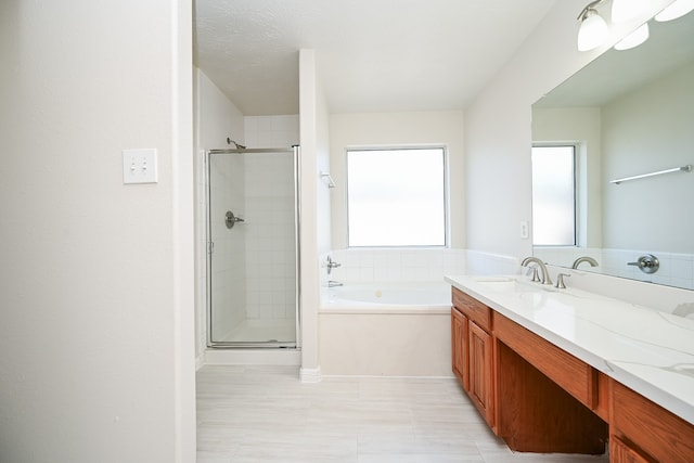 bathroom featuring vanity, separate shower and tub, and a textured ceiling