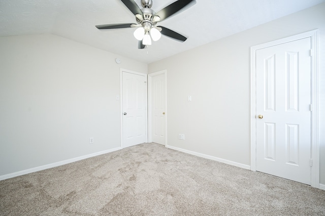 carpeted spare room with vaulted ceiling and ceiling fan