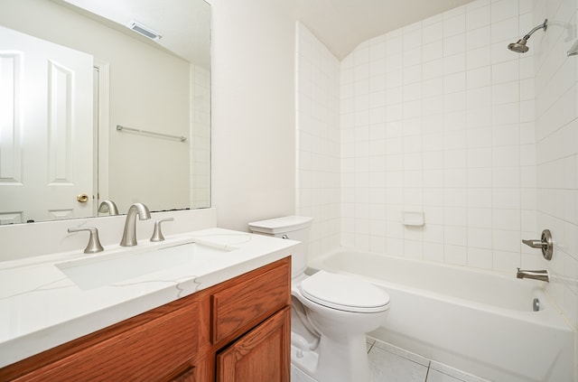 full bathroom with tiled shower / bath, tile patterned floors, vanity, and toilet