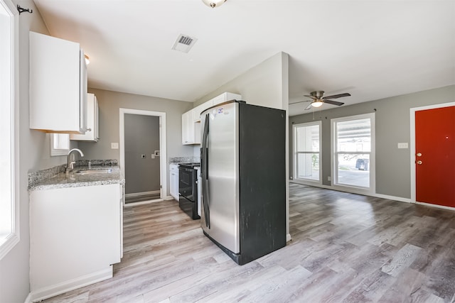 kitchen featuring stainless steel fridge, light wood-type flooring, sink, black range with electric cooktop, and white cabinetry