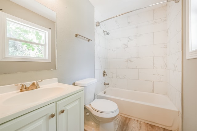 full bathroom featuring hardwood / wood-style flooring, toilet, vanity, and tiled shower / bath combo