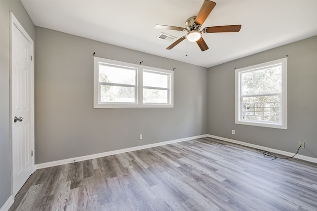 spare room with ceiling fan, light hardwood / wood-style floors, and a healthy amount of sunlight