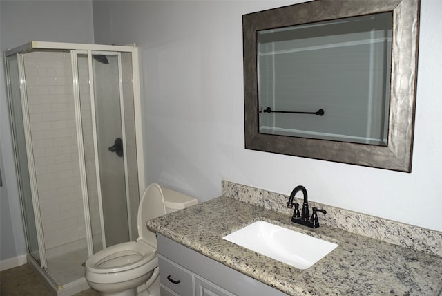 bathroom featuring an enclosed shower, vanity, and toilet