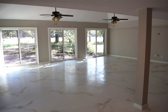 unfurnished room featuring ceiling fan, a textured ceiling, and plenty of natural light