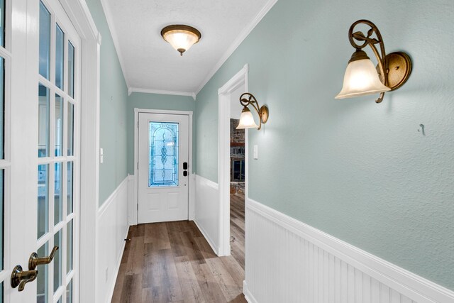 doorway to outside with ornamental molding and light hardwood / wood-style floors