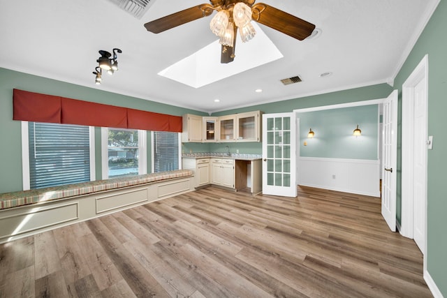 unfurnished living room with crown molding, ceiling fan, and light hardwood / wood-style floors