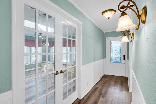 doorway to outside featuring crown molding, a wealth of natural light, dark wood-type flooring, and french doors