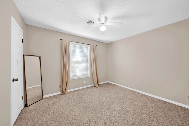 carpeted spare room with ceiling fan and a textured ceiling