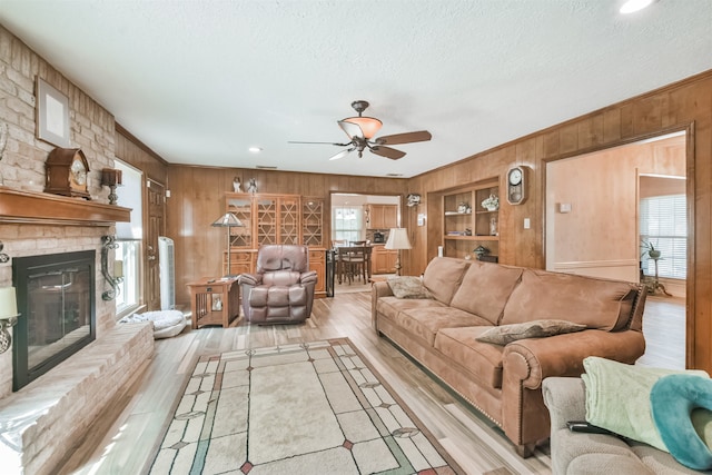 living room featuring light hardwood / wood-style floors, a wealth of natural light, and wooden walls