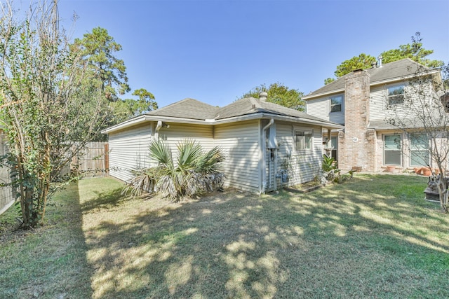 view of side of property featuring fence and a yard