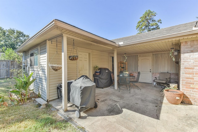 view of patio featuring a grill and fence