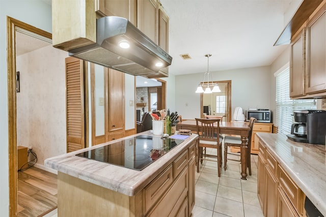 kitchen featuring a center island, range hood, pendant lighting, black electric stovetop, and light tile patterned floors