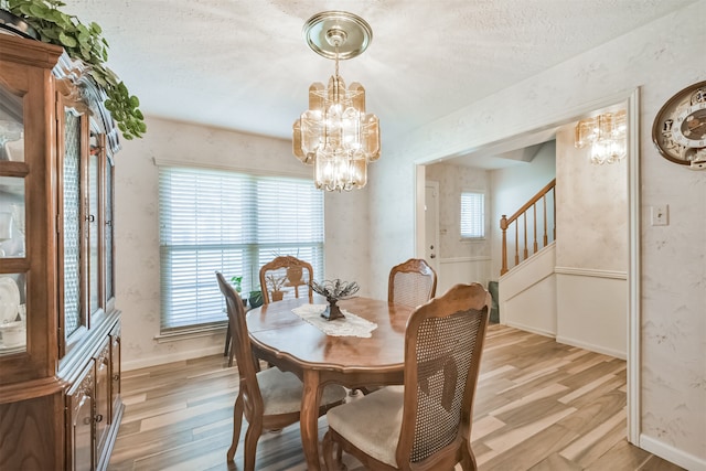 dining room with a chandelier, plenty of natural light, light hardwood / wood-style floors, and a textured ceiling