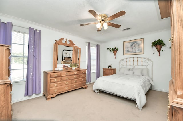 carpeted bedroom featuring ornamental molding and ceiling fan