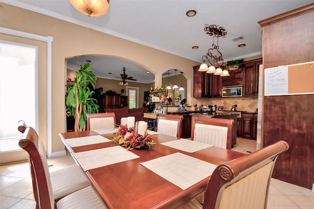 dining room featuring ornamental molding, light tile patterned floors, and ceiling fan with notable chandelier