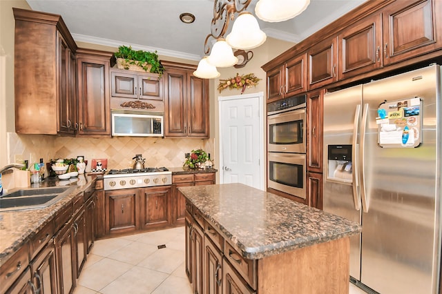 kitchen with hanging light fixtures, ornamental molding, stainless steel appliances, sink, and a center island