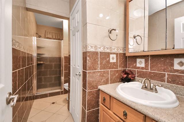 bathroom featuring an enclosed shower, toilet, tile patterned floors, tile walls, and vanity