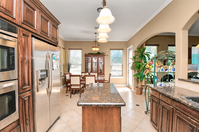 kitchen with crown molding, a center island, pendant lighting, and stainless steel refrigerator with ice dispenser