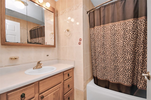 bathroom featuring tile walls, vanity, and shower / bathtub combination with curtain