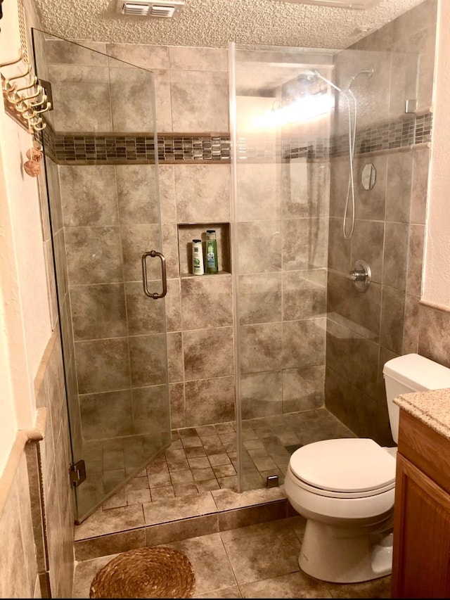 3600 Jeanetta St Unit 502, Houston, TX 77063 - full bathroom featuring tile patterned flooring, toilet, vanity, a stall shower, and a textured ceiling