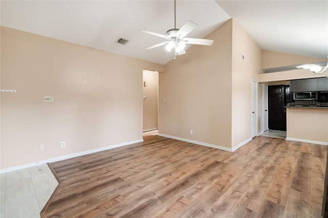 unfurnished living room featuring ceiling fan with notable chandelier, high vaulted ceiling, and light wood-type flooring