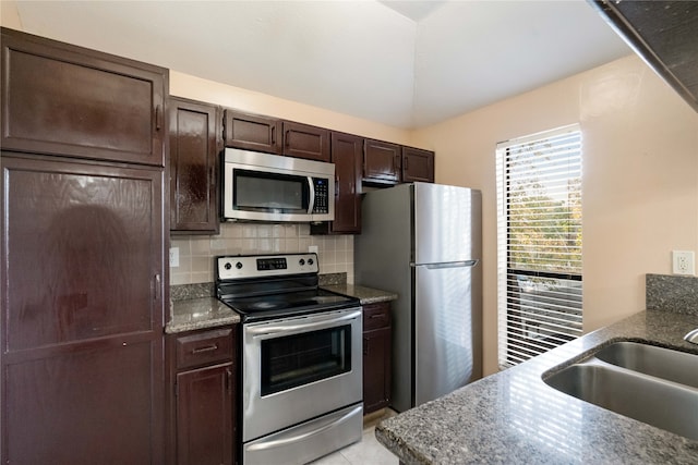 kitchen with decorative backsplash, dark brown cabinetry, sink, stainless steel appliances, and light tile patterned floors