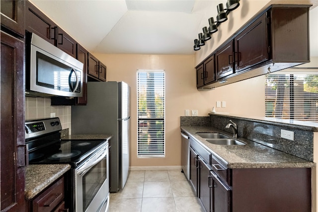 kitchen with light tile patterned flooring, decorative backsplash, dark brown cabinetry, sink, and stainless steel appliances