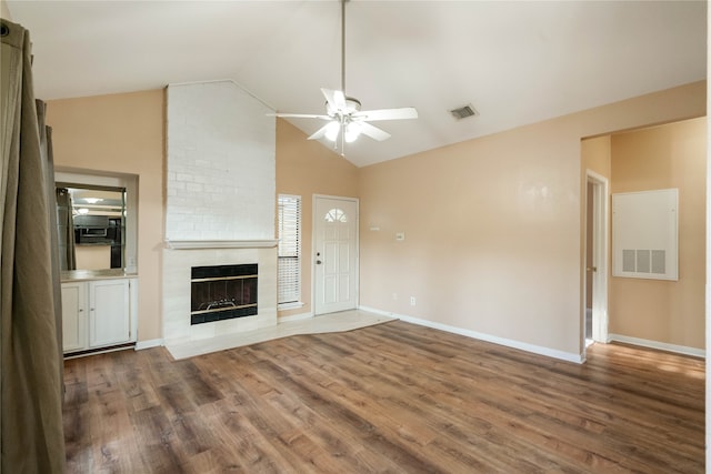 unfurnished living room featuring wood-type flooring, a fireplace, high vaulted ceiling, and ceiling fan