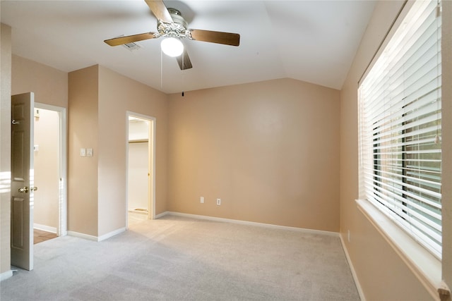 unfurnished bedroom featuring ceiling fan, light carpet, and vaulted ceiling