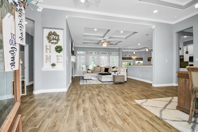 living room with beamed ceiling, ceiling fan, wood-type flooring, crown molding, and coffered ceiling